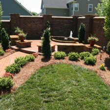 Brick path leading to garden seating area with small water fountain