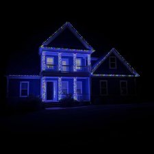 Home decorated with colorful holiday lights outlining roof and columns