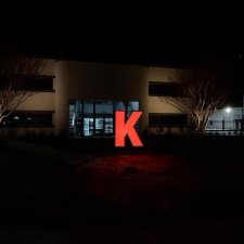 Exterior commercial building at night with red-lit letter K feature