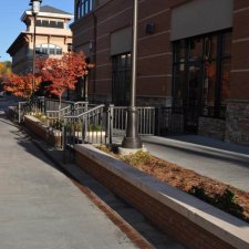 Commercial hardscape featuring stone planter walls and concrete walkways