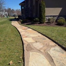 Long flagstone walkway curving through a landscaped front yard