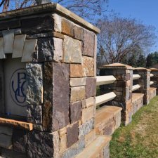 Stone monument entry sign with detailed masonry and accent columns