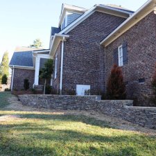 Tiered stone retaining walls along sloped backyard