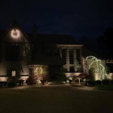 House with wreath and holiday lighting accents at night
