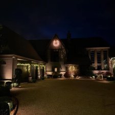 Home exterior with wreath and garage trim lighting during the holidays