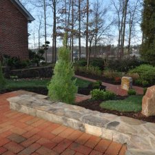 Lakeside garden patio with stone seating and brick walkway