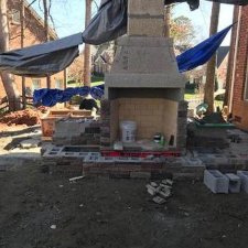 Outdoor fireplace under construction with stonework in progress