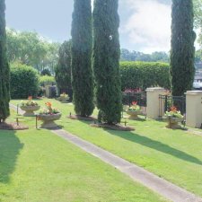 Well-maintained formal garden with tall evergreens and planter beds