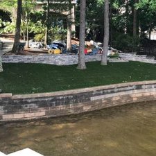 Waterfront yard with fresh artificial turf installation