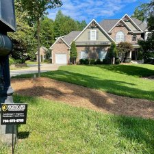 Beautifully maintained front lawn of a residential home with landscaping sign