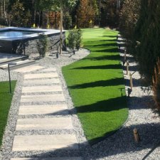 Artificial turf pathway leading to spa with modern landscaping
